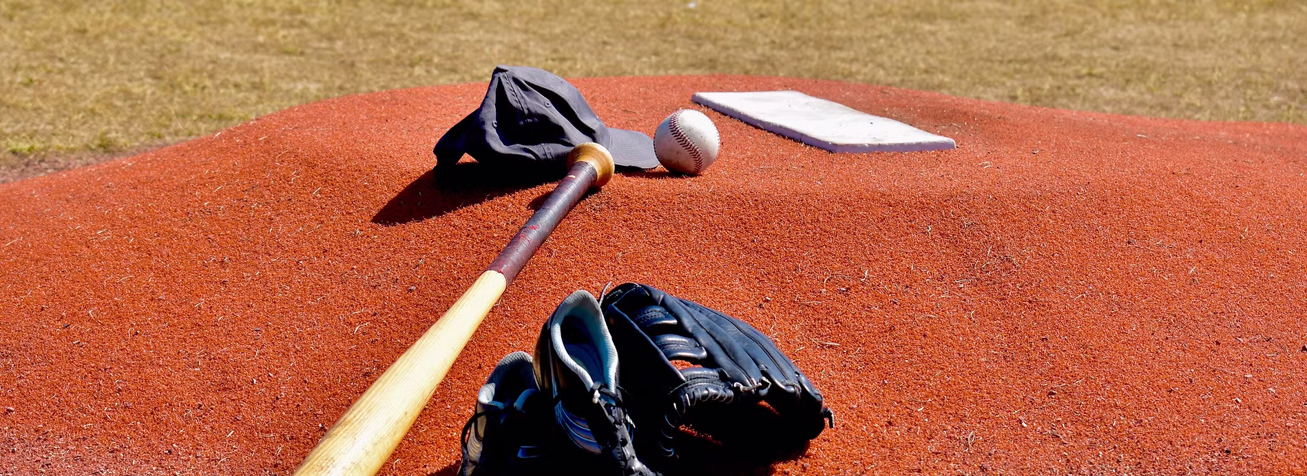 Baseball bat, glove, and ball on pitcher's mound
